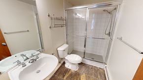 Ann Arbor apartment for rent - A bathroom with a white sink, toilet, and a walk-in shower.