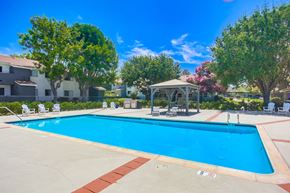 Vista apartment for rent - a swimming pool with a gazebo and chairs around it