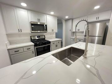 Covina apartment for rent - A kitchen with white cabinets and a stainless steel refrigerator.