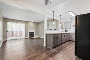 Hemet apartment for rent - A kitchen with a black refrigerator and wooden floors.