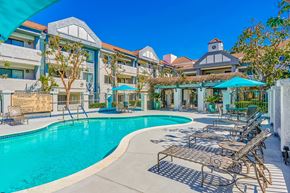 Corona apartment for rent - a swimming pool with lounge chairs and umbrellas