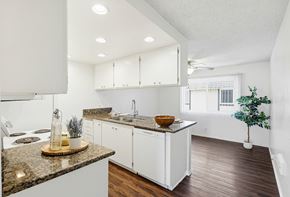 Huntington Beach apartment for rent - A kitchen with white cabinets and a granite countertop.