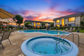 Huntington Beach apartment for rent - A hot tub sits in the middle of a patio with chairs around it.