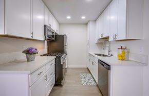 Cypress apartment for rent - A kitchen with white cabinets and a black refrigerator.
