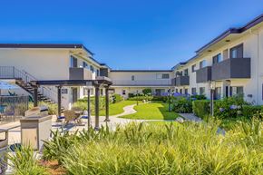 Cypress apartment for rent - A sunny day at a modern apartment complex with a well-maintained lawn and landscaping.