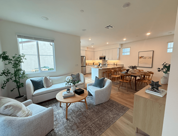 Azusa apartment for rent - A living room with a grey couch, a wooden table, and a dining table with chairs.