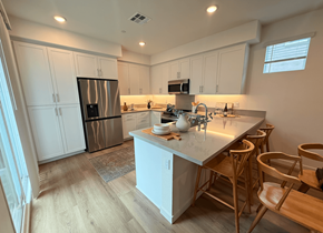 Azusa apartment for rent - A kitchen with a white counter and wooden chairs.