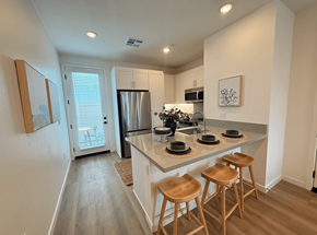 Azusa apartment for rent - A kitchen with a refrigerator, microwave, and two bar stools.