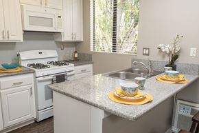 Claremont apartment for rent - A kitchen with a granite countertop and white appliances.