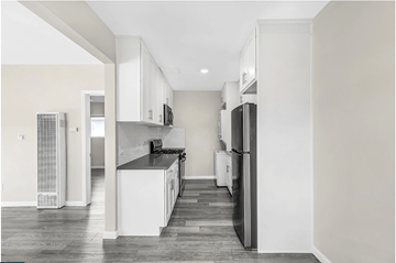 Westminster apartment for rent - A kitchen with white cabinets and a black countertop.