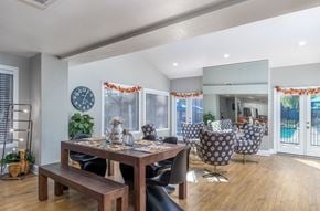 Hemet apartment for rent - A dining room with a table set for four and a clock on the wall.