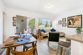 Pasadena apartment for rent - A dining room with a table set for four and a couch with a pillow.