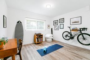 Pasadena apartment for rent - A room with a surfboard, a bicycle, and a dining table.