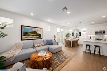 Fontana apartment for rent - A living room with a grey couch, a coffee table, and a painting on the wall.