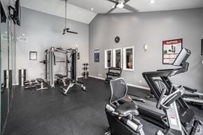 Anaheim apartment for rent - A spacious gym with a variety of equipment including treadmills, weights, and a bench press.