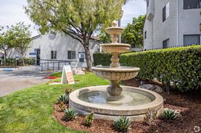 Anaheim apartment for rent - A stone fountain is in the middle of a grassy area.
