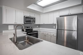 Anaheim apartment for rent - A kitchen with a stainless steel refrigerator, sink, and stove.
