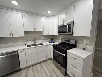 Fullerton apartment for rent - A kitchen with white cabinets and stainless steel appliances.
