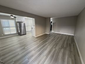 Fullerton apartment for rent - A room with a wood floor and a refrigerator.