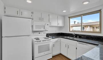 Huntington Beach apartment for rent - A kitchen with white appliances and cabinets.