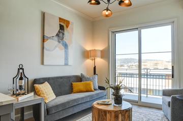 Los Angeles apartment for rent - A living room with a grey couch, a table with a lamp and a painting on the wall.