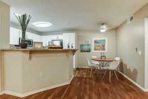 Palm Springs apartment for rent - a dining room with a table and chairs in front of a kitchen with a bar