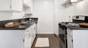 Tustin apartment for rent - Modern kitchen with black countertops, white cabinets, and gas stove