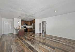 Loma Linda apartment for rent - the living room and kitchen of an apartment with wooden floors and white walls