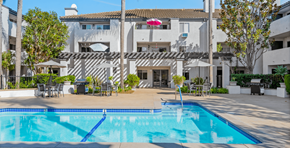 Garden Grove apartment for rent - a swimming pool in front of a white building with a pool