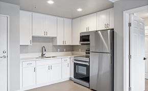 Garden Grove apartment for rent - A modern kitchen with white cabinets and stainless steel appliances.