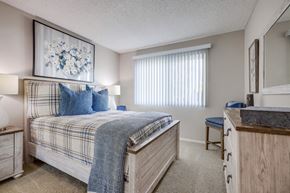 Cypress apartment for rent - a bedroom with a bed and a dresser and a window
