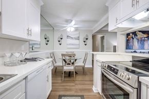 Cypress apartment for rent - a kitchen and dining room with white cabinets and stainless steel appliances