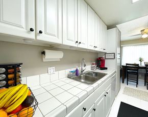 Costa Mesa townhouse for rent - A kitchen with white cabinets and a black mat on the floor.