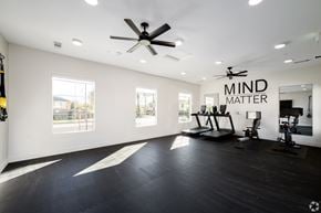 Fontana apartment for rent - A spacious room with a ceiling fan and exercise equipment.