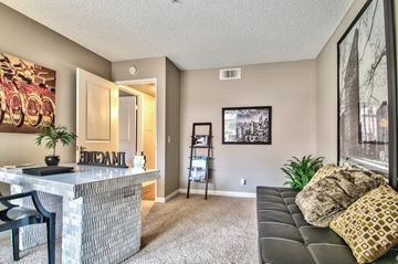 Palm Springs apartment for rent - A living room with a black couch and a bar area.