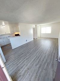 Huntington Beach apartment for rent - an empty living room with a kitchen in the background