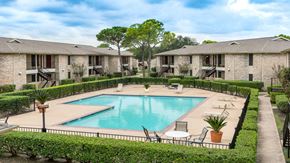Houston apartment for rent - a swimming pool with chairs around it in front of apartments