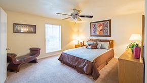 Houston apartment for rent - a bedroom with a bed and a ceiling fan