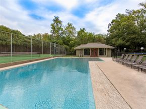 Austin apartment for rent - a swimming pool with a tennis court and a house in the background