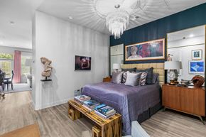 Jackson apartment for rent - A bedroom with a purple bed and a wooden nightstand at The Quarter Lofts Apartments, Jackson, MS, 39216