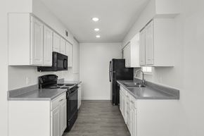 Jackson townhouse for rent - A black refrigerator sits in a kitchen with white cabinets.