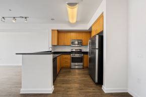 Canoga Park apartment for rent - an empty apartment kitchen with black countertops and stainless steel appliances