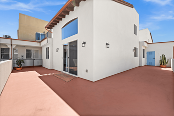 A white house with a patio and a blue door