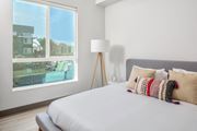 Canoga Park apartment for rent - a bedroom with a large window and a bed with pillows
