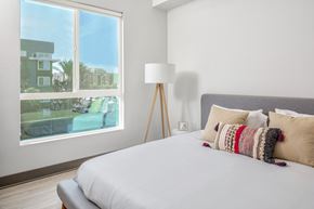 Canoga Park apartment for rent - a bedroom with a large window and a bed with pillows