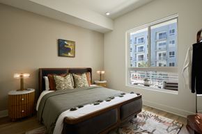 Woodland Hills apartment for rent - A bedroom with a large bed and a window overlooking a cityscape.