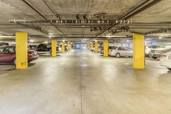 A parking garage with cars and yellow pillars