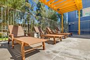 Northridge apartment for rent - A sunny day at the outdoor seating area with wooden benches and tables.