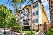 Van Nuys apartment for rent - an apartment building with palm trees and a blue and white street sign