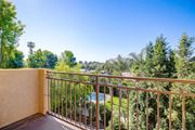 Van Nuys apartment for rent - a balcony with a view of a pool and trees